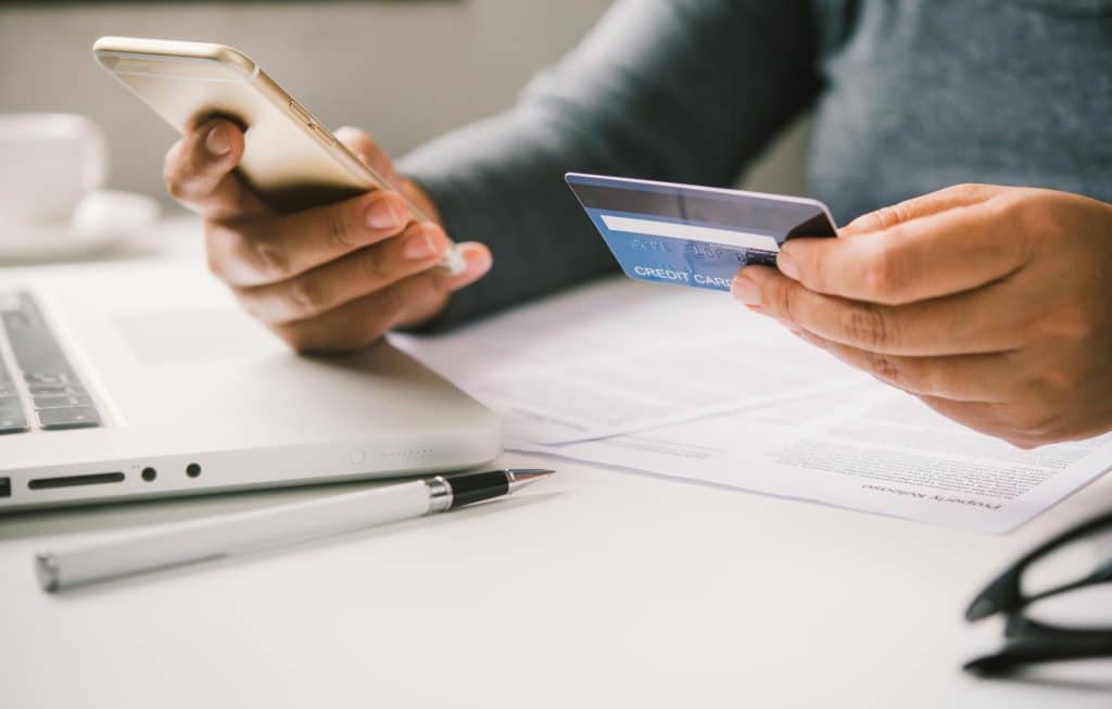 persona con tarjeta de credito y móvil